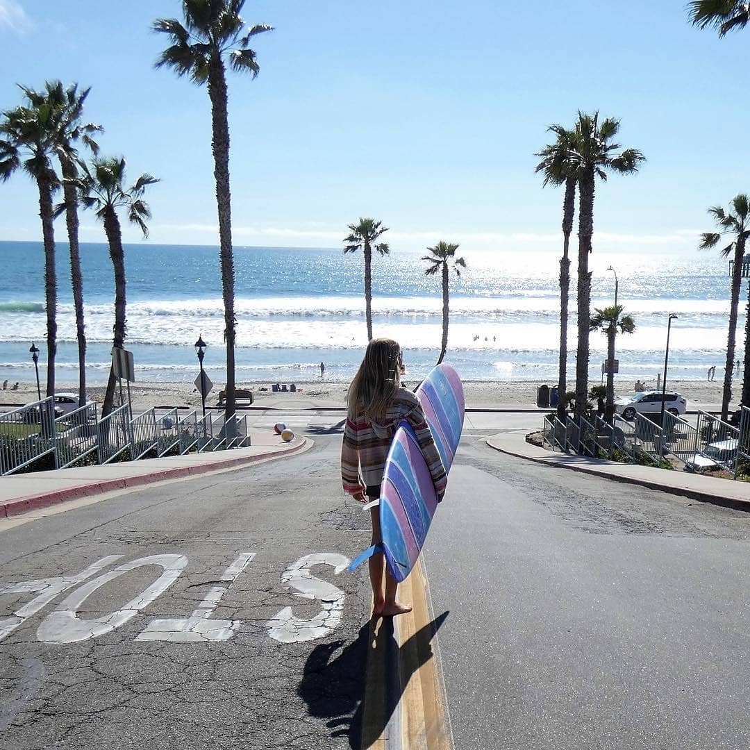 Shark Tooth Surf Co Team Rider Avalon Besso heading to the beach for a surf session